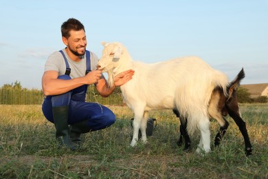 Photo of Man with goats at farm. Animal husbandry