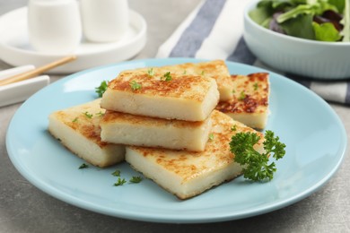 Photo of Delicious turnip cake with parsley served on grey table