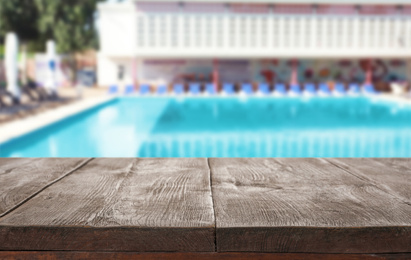Wooden deck near swimming pool outdoors on sunny day. Space for text