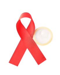 Red ribbon and condom isolated on white, above view. AIDS disease awareness
