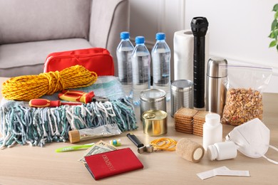 Photo of Disaster supply kit for earthquake on wooden table at home