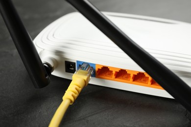 Modern Wi-Fi router on black table, closeup