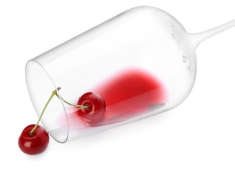 Overturned glass of delicious cherry wine and ripe juicy berries isolated on white
