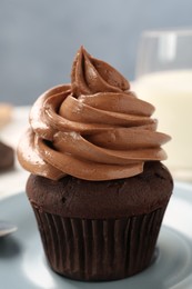 Photo of Delicious fresh chocolate cupcake on saucer, closeup