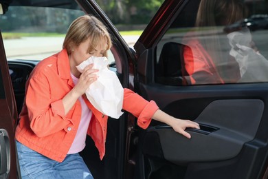 Woman with paper bag suffering from nausea in car