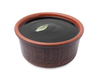 Photo of Balsamic glaze with basil leaf in bowl isolated on white