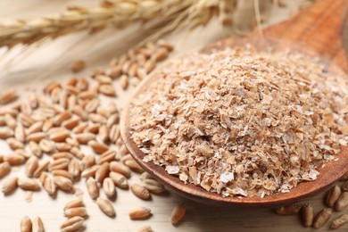 Wheat bran and kernels on wooden table, closeup
