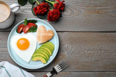 Romantic breakfast and roses on wooden table, flat lay with space for text. Valentine's day celebration