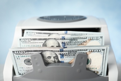 Photo of Modern bill counter with money, closeup view