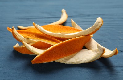 Photo of Orange peels preparing for drying on blue wooden table, closeup