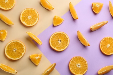 Slices of delicious oranges on color background, flat lay