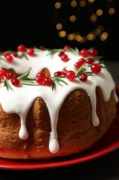 Photo of Traditional Christmas cake decorated with glaze, pomegranate seeds, cranberries and rosemary, closeup