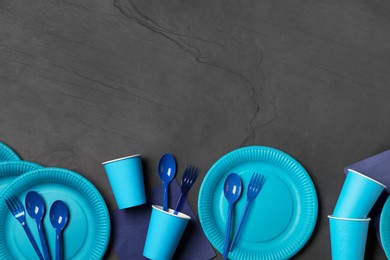 Bright disposable tableware on black background, flat lay. Space for text