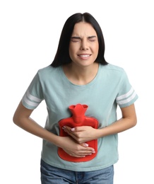 Woman using hot water bottle to relieve abdominal pain on white background
