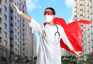 Doctor dressed as superhero on city background. Medical workers fighting with dangerous diseases