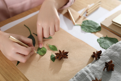 Little girl working with natural materials at table, closeup. Creative hobby