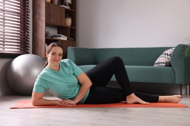 Overweight woman on yoga mat at home