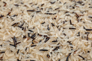 Mix of different brown and polished rice as background, closeup