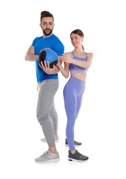Athletic couple doing exercise with medicine ball on white background