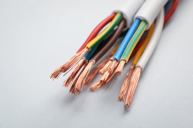 Cables with stripped wires on light background, closeup