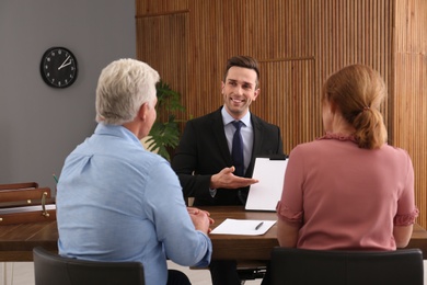 Young lawyer consulting senior couple in office