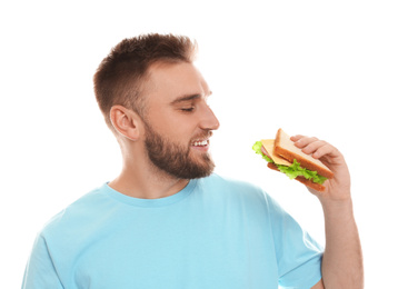 Photo of Young man eating tasty sandwich on white background