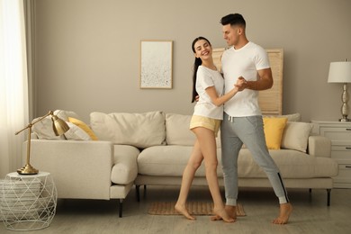 Photo of Happy couple in pyjamas dancing at home