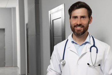 Doctor in white coat with stethoscope indoors. Space for text