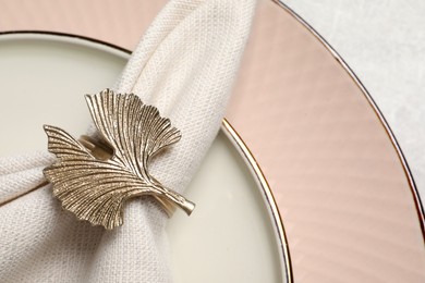 Photo of Fabric napkin and decorative ring on plate, closeup. Space for text