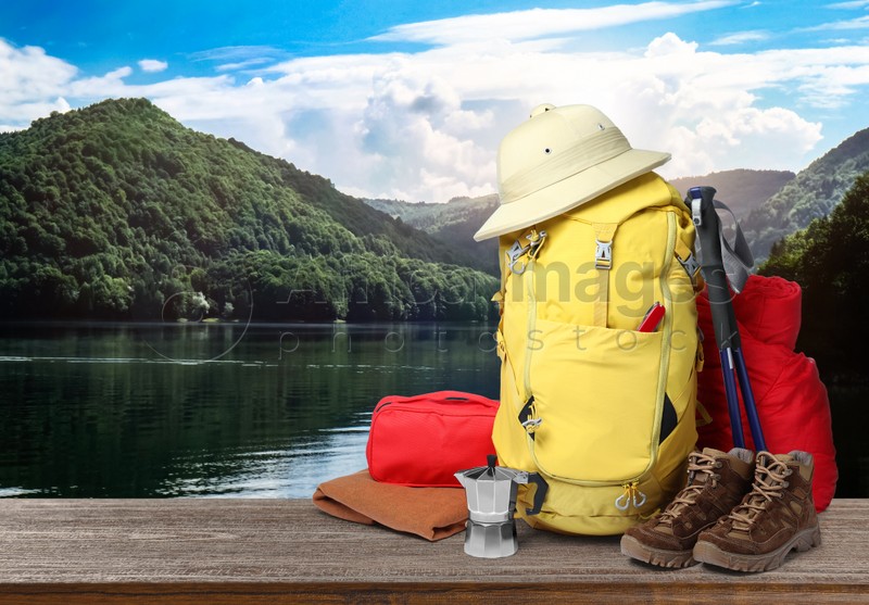 Camping equipment for tourist on wooden surface and beautiful view of mountain landscape