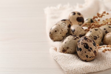 Fresh quail eggs on white wooden table. Space for text