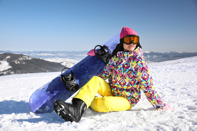 Young woman with snowboard on hill. Winter vacation
