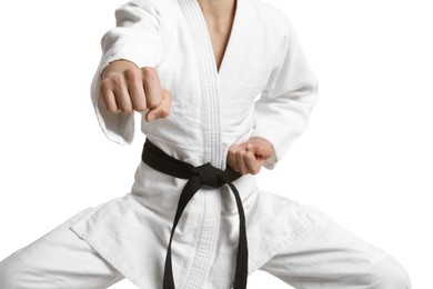 Martial arts master in keikogi with black belt against white background, focus on fist