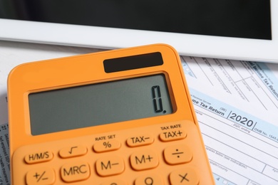 Calculator, tablet and documents on table, closeup. Tax accounting