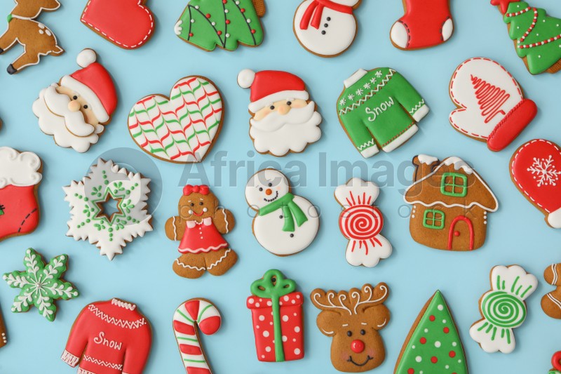 Different Christmas gingerbread cookies on light blue background, flat lay