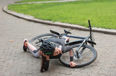 Photo of Young woman fallen off her bicycle in park