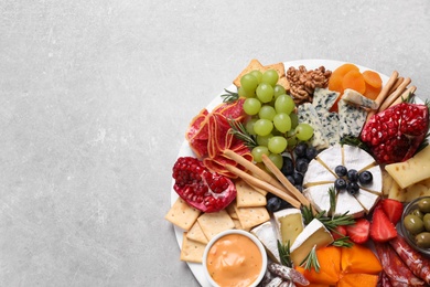 Photo of Assorted appetizers served on light grey table, top view. Space for text
