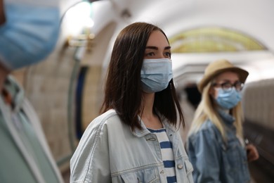 Young woman in protective mask at subway station. Public transport