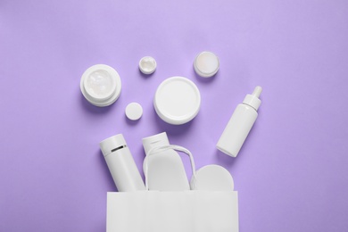 Flat lay composition with cosmetic products on violet background