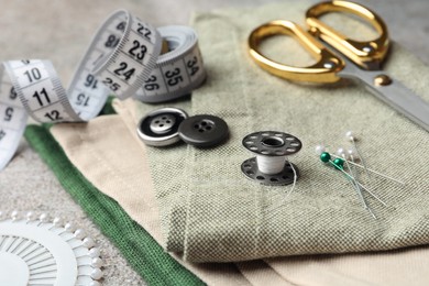 Photo of Spools of threads and sewing tools on table, closeup