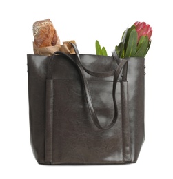 New leather shopper bag with purchases on white background