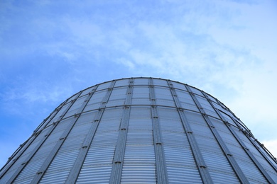 Modern granary for storing cereal grains against blue sky, low angle view