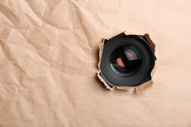 Photo of Hidden camera lens through hole in paper. Space for text