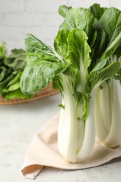 Fresh green pak choy cabbages on light table, closeup