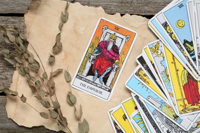 Flat lay composition with Emperor and other tarot cards on wooden table