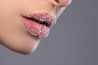 Photo of Woman with beautiful lips covered in sugar on grey background, closeup. Space for text