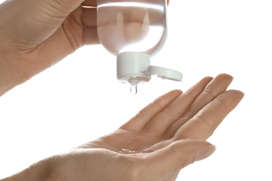 Woman applying antibacterial hand gel against white background, closeup