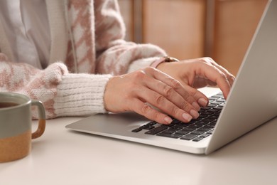Woman with modern laptop learning at table indoors, closeup