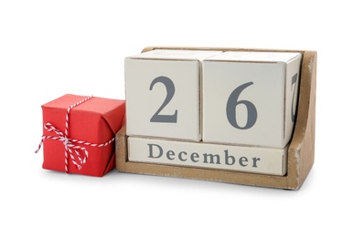 Wooden block calendar with date 26th of December near gift on white background. Boxing day