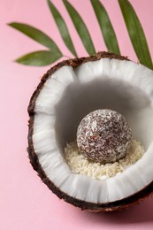 Photo of Composition with delicious vegan candy ball and coconut on pink background